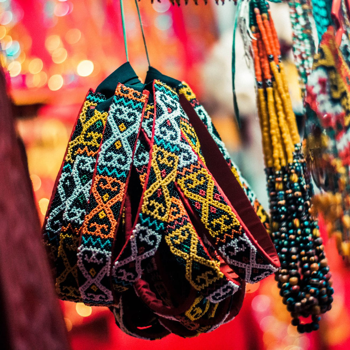 Vibrant traditional beaded accessories hanging in an Indonesian market, showcasing cultural craftsmanship.
