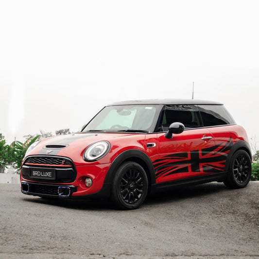 Photo of a stylish red and black Mini Cooper parked outdoors.