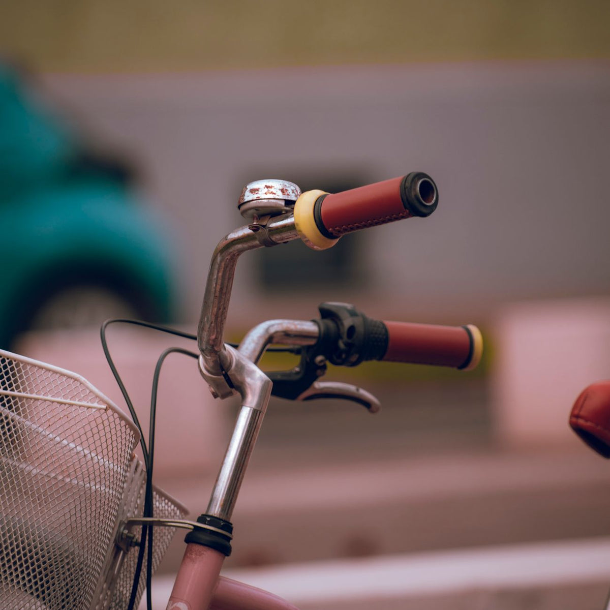 Detailed view of a bicycle's handlebars with a bell and a basket, ideal for transportation themes.