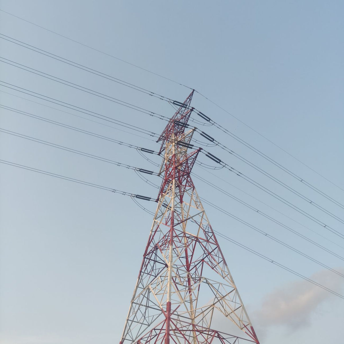 Steel transmission tower with wires on a clear day, showcasing modern electrical infrastructure.