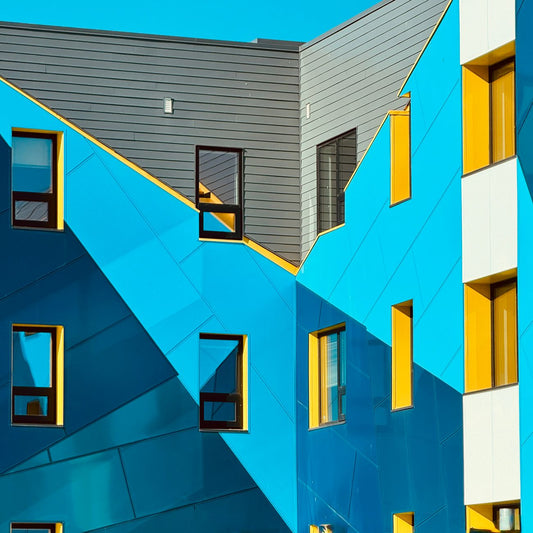 A vibrant and dynamic facade featuring bright blue and yellow geometric patterns, creating an eye-catching architectural design.