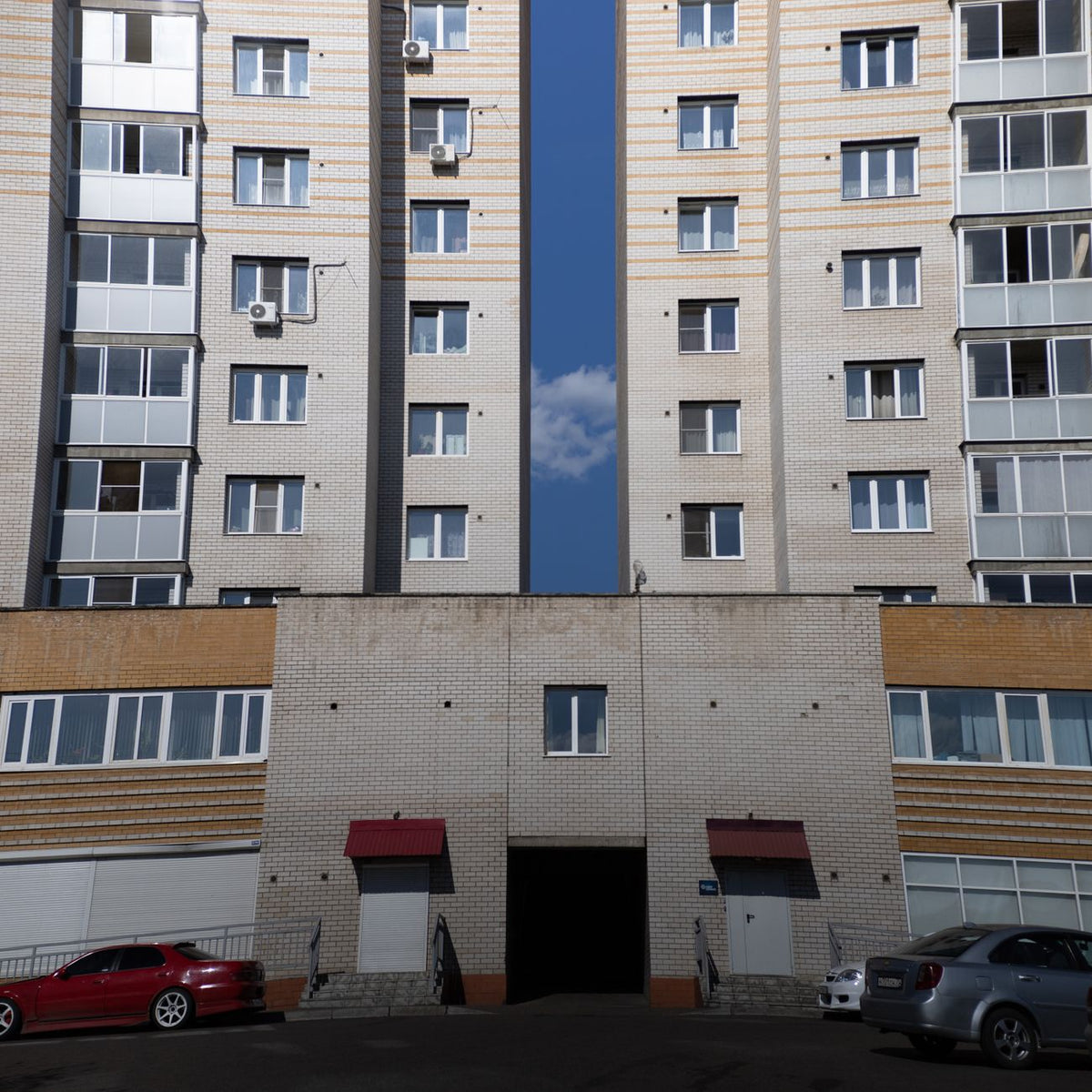 Symmetrical view of a modern residential building's facade against a clear blue sky.