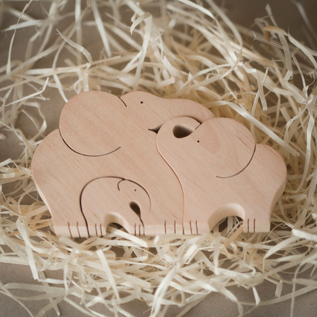 Charming wooden elephant puzzle set in natural straw, perfect for kids.