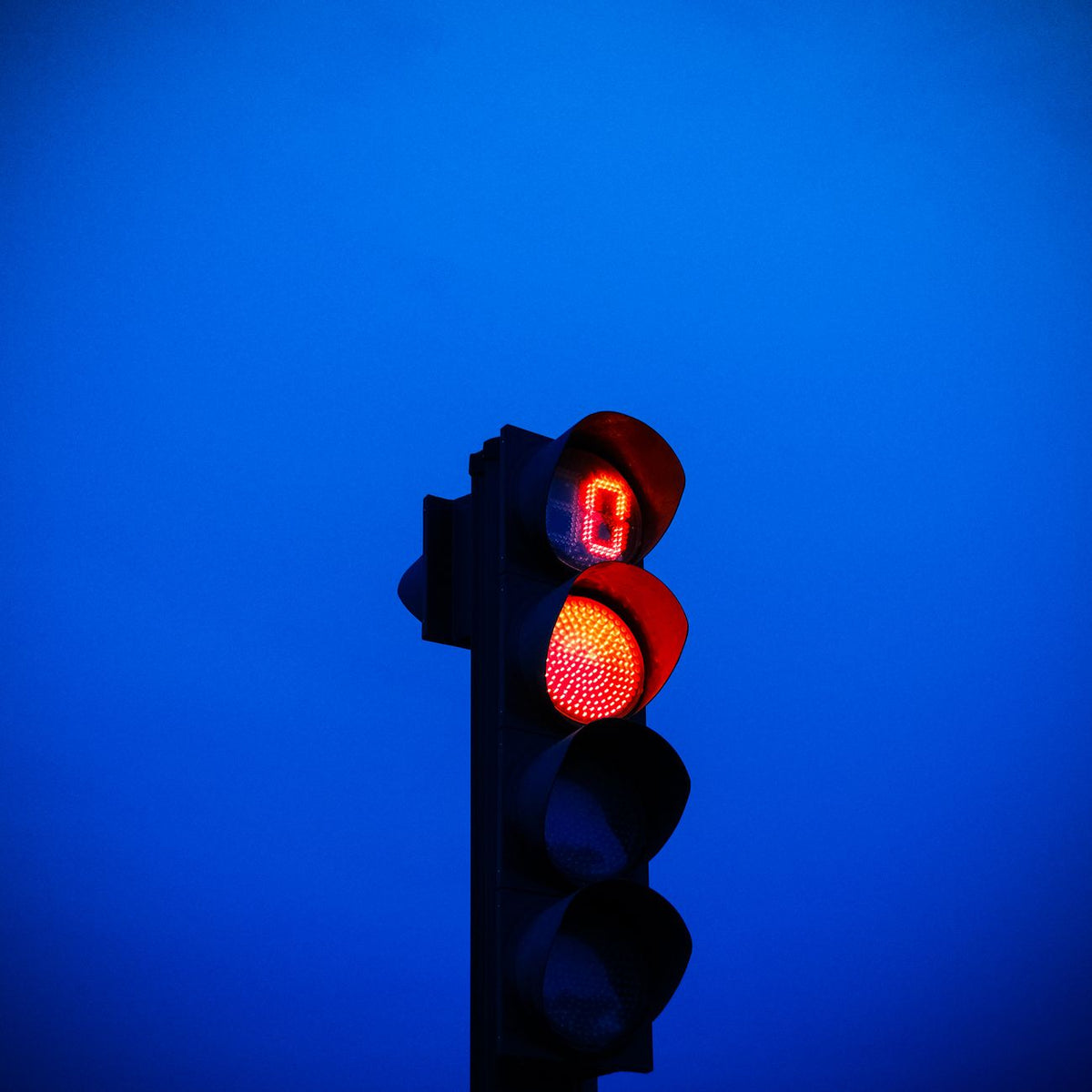 Low angle of illuminated red traffic light for controlling traffic at road junctions and crosswalks