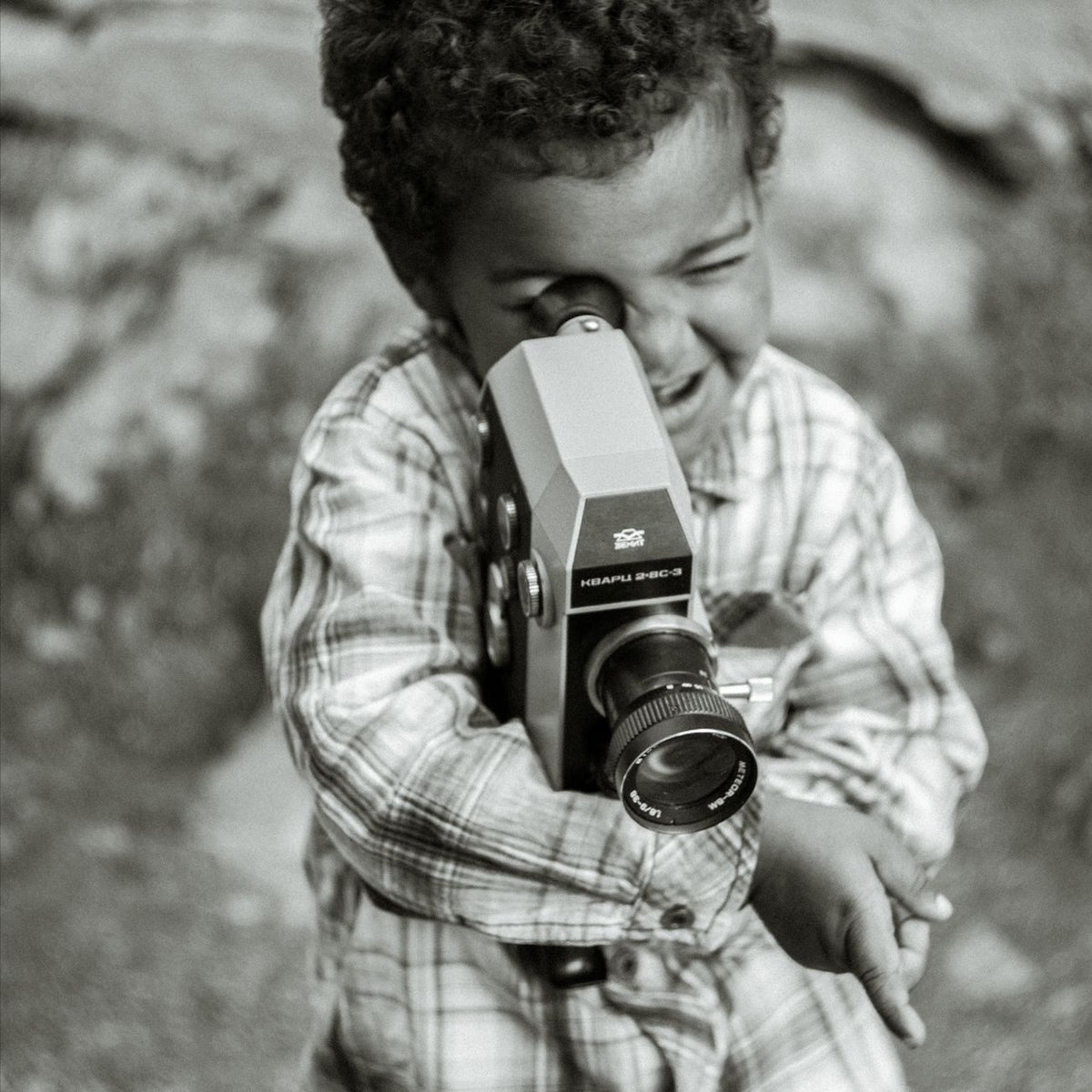 A joyful child holds a vintage camera, capturing moments of innocence and creativity.