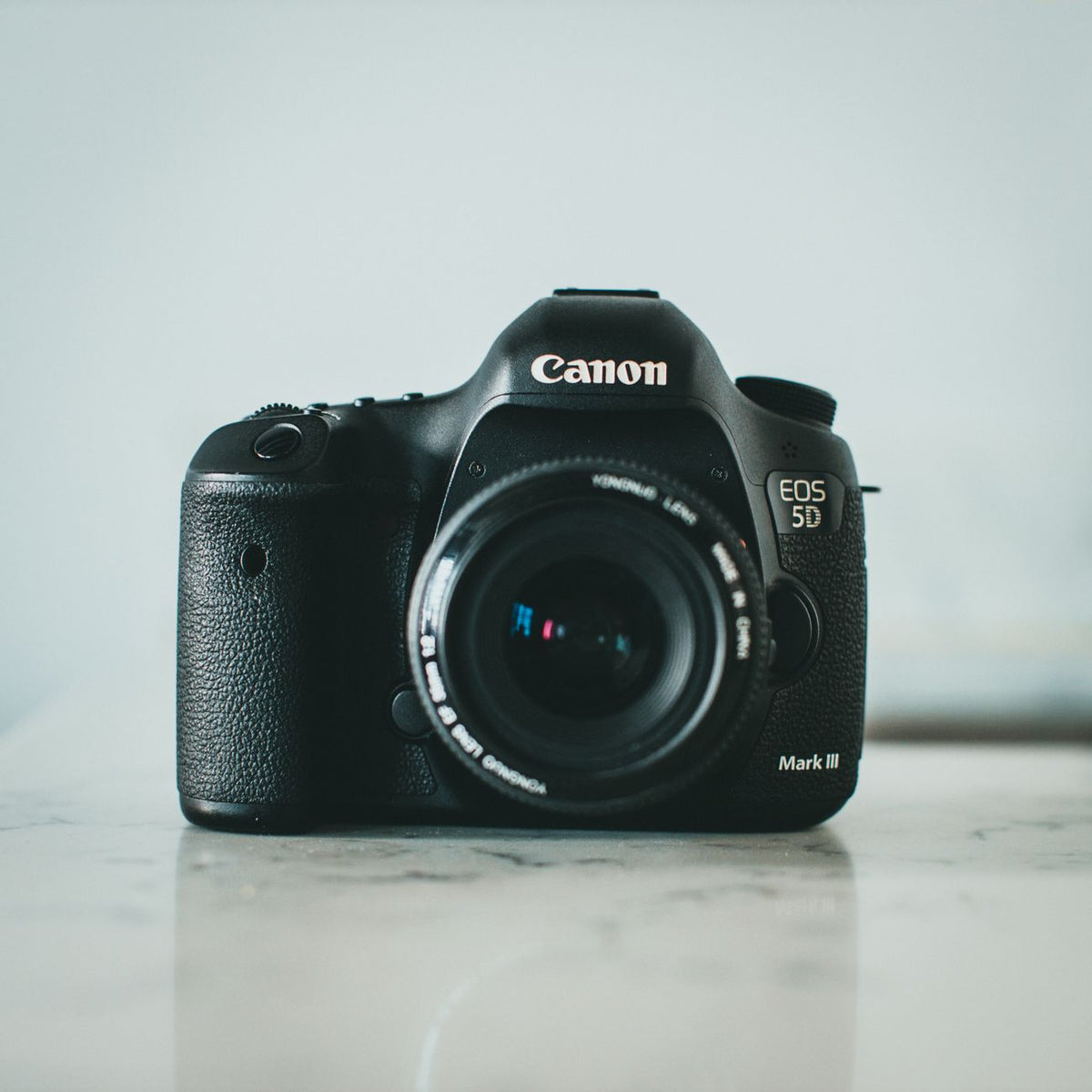 High-quality Canon DSLR camera displayed elegantly on a marble surface.